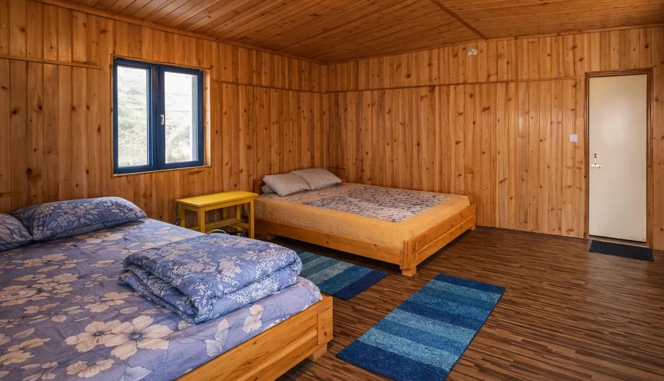 Rigsel Homestay Double Bed Room — warm wooden interiors with natural light and Kalimpong hill views